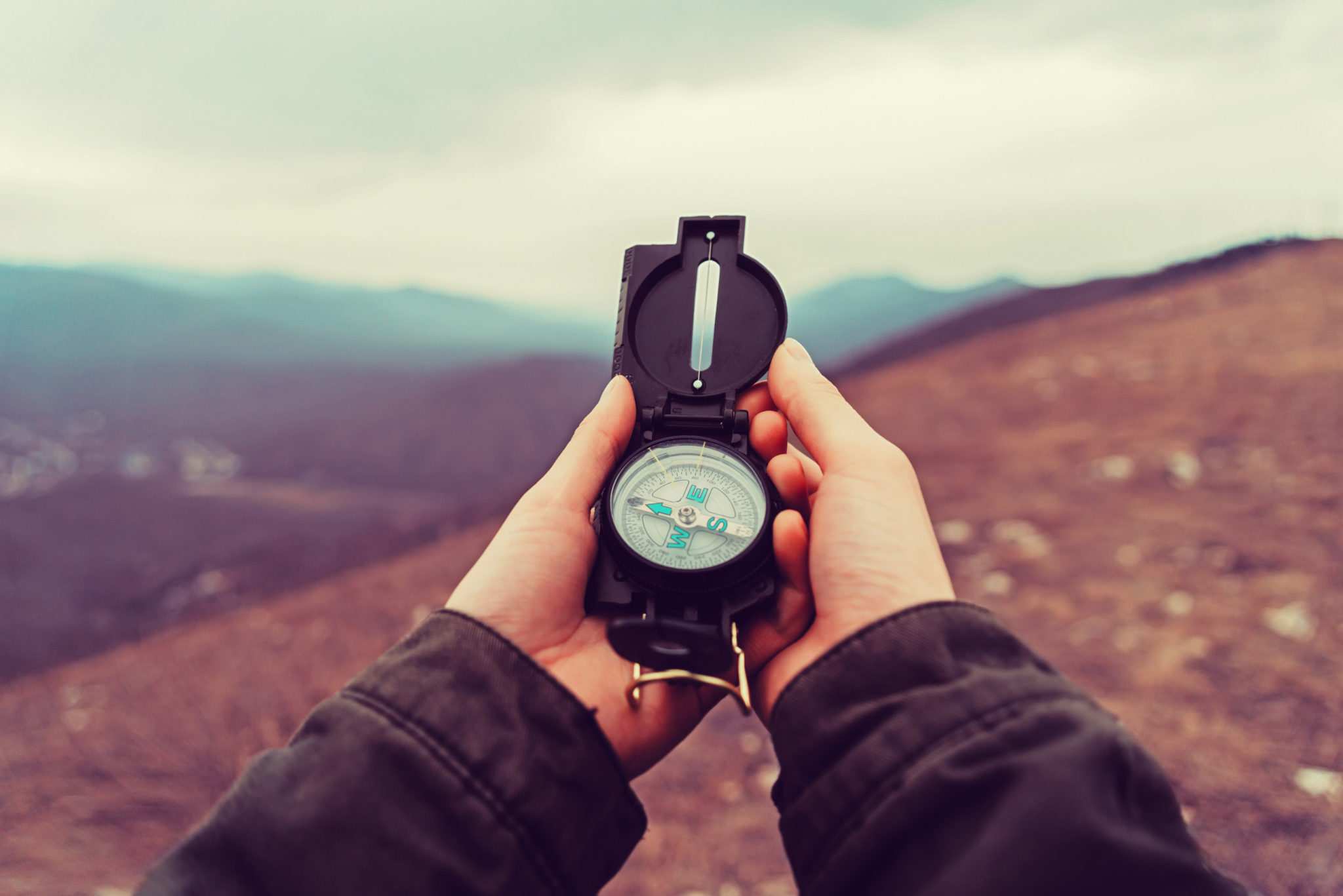Hiker woman with a compass in the mountains